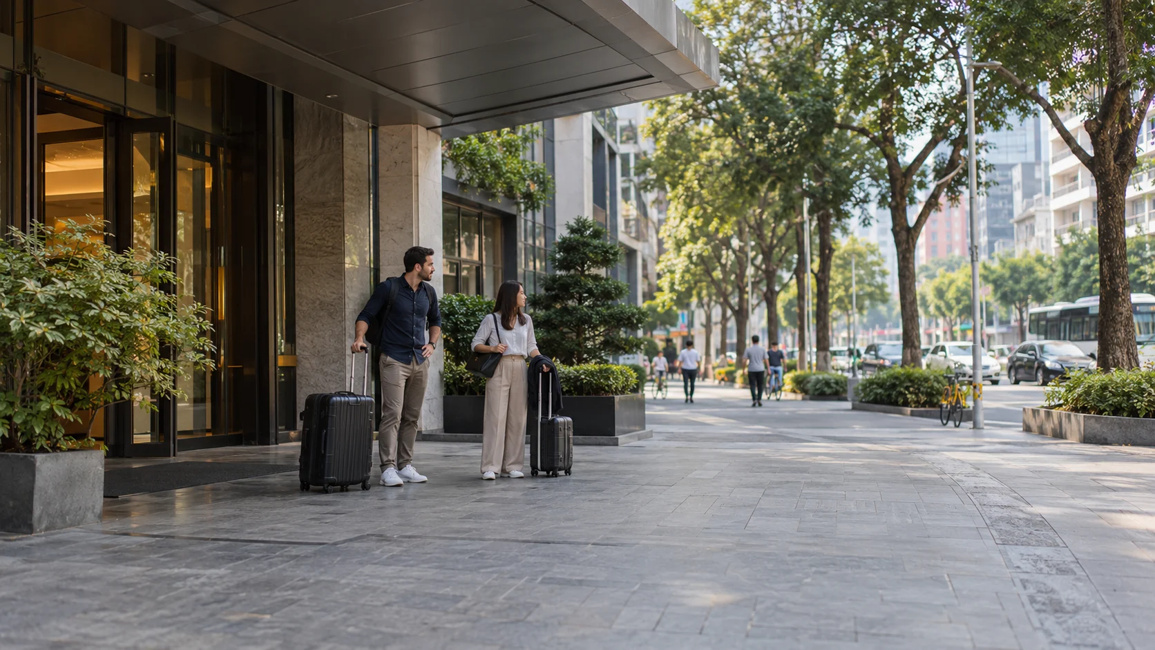 Business travellers with wheeled luggage outside a hotel entrance before their onward journey